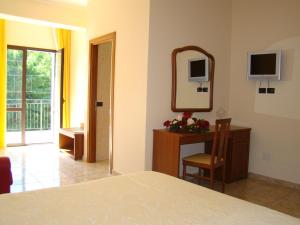 a bedroom with a bed and a mirror and a chair at Hotel Ristorante111 in Villapiana