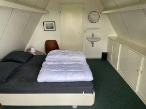 a small bedroom with a bed and a sink at Vakantiewoning Sneekermeer, huur sloep of zeilboot mogelijk in Goingarijp