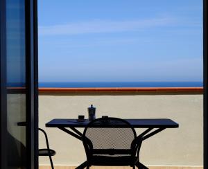 una mesa azul y una silla sentadas frente a una ventana en Case Vacanza Villa Doria, en Valledoria
