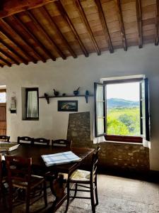 une salle à manger avec une table et une grande fenêtre dans l'établissement Fattoria Montignana, à San Casciano in Val di Pesa