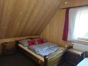 a bed in a room with a wooden ceiling at Domek góralski Toporówka in Murzasichle