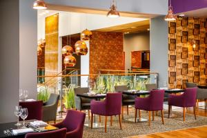 una sala da pranzo con tavoli e sedie viola di Radisson Blu Hotel, Cardiff a Cardiff