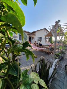 a group of people sitting in a hammock in a yard at Salty Jackal Backpackers & Surf Camp in Swakopmund