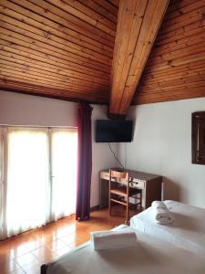 um quarto com 2 camas e uma secretária com uma cadeira em Albergo Villa Mimosa em Nago-Torbole