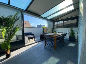 patio con mesa de madera y sillas en el balcón en Maison de plage, plain-pied, 3 chambres, en Colleville-Montgomery