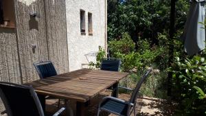 a wooden table and chairs in a yard at Les Pucines bis Bas de villa 29 m2 luxe rez de jardin climatisation plein sud in Six-Fours-les-Plages
