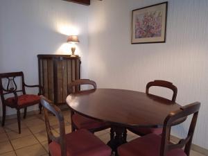 a dining room with a wooden table and chairs at Charming detached 2 bedroom ancient house in medieval quarter of a small town in the Pays de la Loire, France in Sillé-le-Guillaume