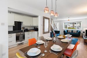 eine Küche und ein Esszimmer mit Tisch und Stühlen in der Unterkunft Merlins Gardens in Tenby
