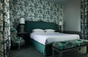 a green bedroom with a bed and a chair at COMO Le Montrachet in Puligny-Montrachet