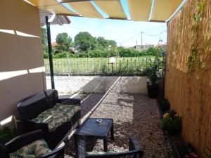 een patio met een bank, een tafel en een hek bij La casetta in Roda