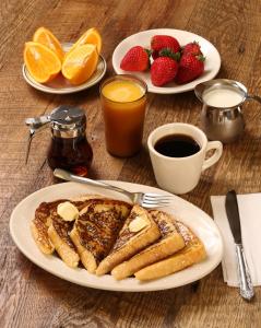 a table with two plates of french toast and fruit at Hotel Gross International near delhi airport in New Delhi