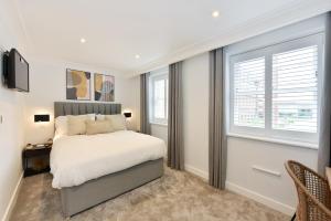 a bedroom with a bed and two windows at James Street Serviced Apartments by Globe Apartments in London
