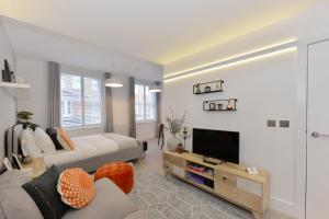 a living room with a couch and a tv at James Street Serviced Apartments by Globe Apartments in London