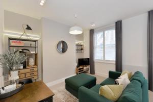 a living room with a green couch and a table at James Street Serviced Apartments by Globe Apartments in London