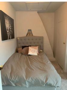 een slaapkamer met een bed met een grijs hoofdeinde bij charmigt radhus i centrala Göteborg in Göteborg