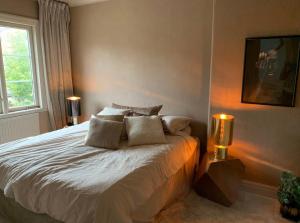 a bedroom with a large bed with two lamps at charmigt radhus i centrala Göteborg in Gothenburg