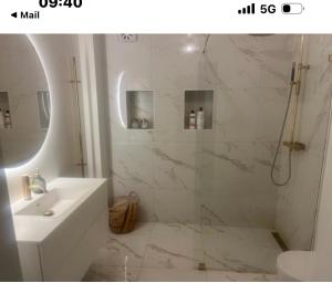 a white bathroom with a shower and a sink at charmigt radhus i centrala Göteborg in Gothenburg +3 photos