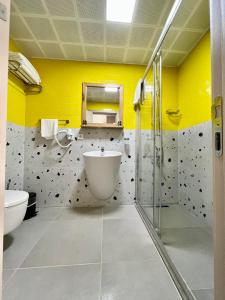 uma casa de banho com um lavatório, um WC e paredes amarelas em Hotel Panaya em Gokceada Town