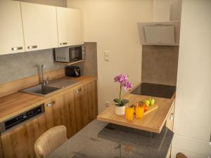 a kitchen with a wooden table with fruit on it at Panorama Superior Apartments - Pool, garden, parking in Balatonalmádi