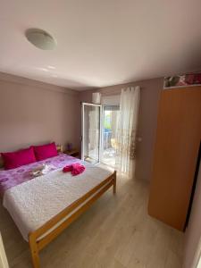 sypialnia z dużym łóżkiem z różowymi poduszkami w obiekcie Apartments Klikovac Liman II w Ulcinju