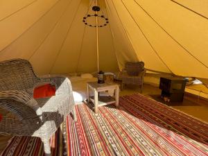 a room with a tent with a chair and a table at Grange de Lesse in Libin