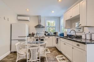 uma cozinha com armários brancos e uma mesa e cadeiras em Nini's Cottage 4bd 3ba Vacation Rental em West Palm Beach