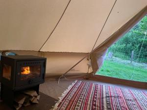 a fireplace in a tent with a stove in a room at Grange de Lesse in Libin
