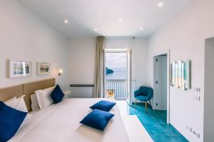 Habitación de hotel con cama grande con almohadas azules en Casa Dolce Casa en Ravello