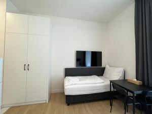 a small bedroom with a bed and a table at Figaro Suites in Prague