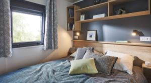 1 dormitorio con cama con almohadas y ventana en Kampari, en Delfstrahuizen