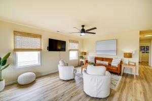 a living room with white furniture and a ceiling fan at Nags Head Vacation Rental with Hot Tub Near Beach! in Nags Head