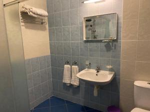 a bathroom with a sink and a mirror and a toilet at Guest House Golden Flake 4km from Bolata beach in Bŭlgarevo