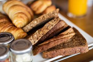 een bord brood, croissants en croissants bij BnB Pastel in Dilsen-Stokkem