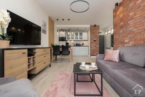 una sala de estar con un sofá y una mesa en Apartament RiverView Bridge Apartments & Spa Dziwnów Epapartamenty, en Dziwnów