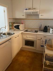 eine kleine Küche mit Spüle und Mikrowelle in der Unterkunft Apartamento premium Canela Park in Isla Canela
