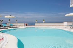 a large swimming pool with a view of the ocean at Mar Hotel Alimuri in Meta