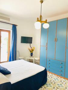 a bedroom with a bed and a blue cabinet at Casa Colomba in Anacapri