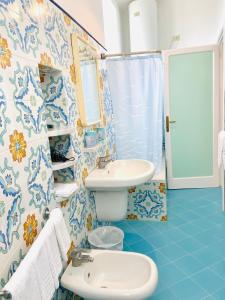 a blue and white bathroom with a sink and a toilet at Casa Colomba in Anacapri