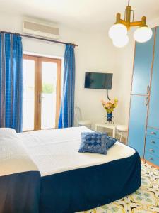 a bedroom with a large bed with blue curtains at Casa Colomba in Anacapri