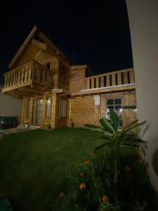 a house at night with a large yard at كوخ السحاب in Al Hada