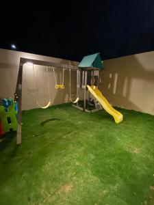 a play room with a playground with a slide at كوخ السحاب in Al Hada