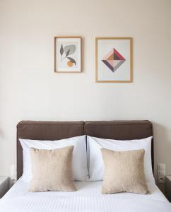 - un lit avec 2 oreillers et 2 photos sur le mur dans l'établissement Magazynowa Classy Apartment, à Varsovie