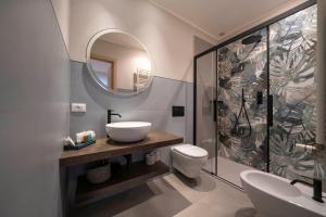 a bathroom with a sink and a toilet and a mirror at Porto Ercole Guest House in Porto Ercole