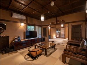 uma sala de estar com uma mesa e um sofá em Nihon-no-Ashitaba em Yufu