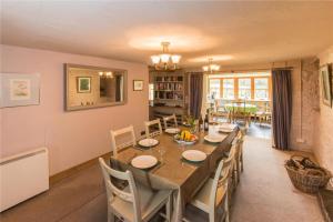 un comedor con una mesa larga y sillas en Baddegai Holiday Cottage, en Brecon