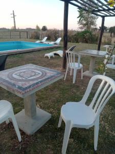 un grupo de sillas y una mesa y una mesa y sillas en Hospedaje El Rincon en San Antonio de Areco