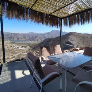 einen Tisch und Stühle auf einer Terrasse mit Bergblick in der Unterkunft Casa Puclaro, terraza panorámica Valle del Elqui in Vicuña