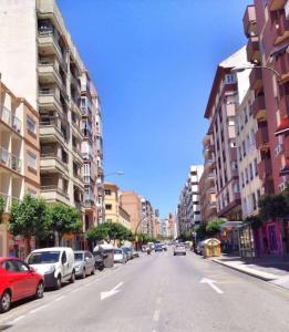 una calle de la ciudad con coches estacionados al costado de la carretera en Apartment Cristo de la Epidemia Malaga by SharingCo, en Málaga