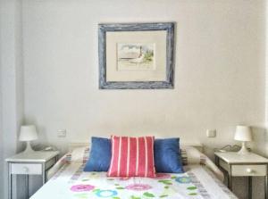 1 dormitorio con 1 cama con 2 mesas y una foto en la pared en Apartment Cristo de la Epidemia Malaga by SharingCo, en Málaga
