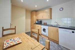 a kitchen with a table and a washing machine at Host & Stay - Scotsgate House in Berwick-Upon-Tweed +12 photos